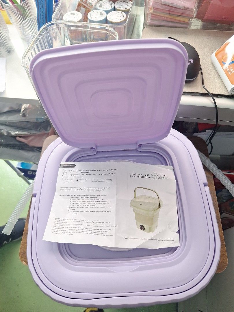 Multi-Function Folding Washing Machine （分類：洗衣機及乾衣機）位於 Hong Kong。 由 Bienvenu 提交（商品編號 1424948175，圖片 2）。簡介： Multi-function folding washing machine. It is a compact, portable washing machine. The machine is purple and white. It has a lid and a handle for easy carrying. It comes with installation instructions. The machine has a control panel with buttons.。