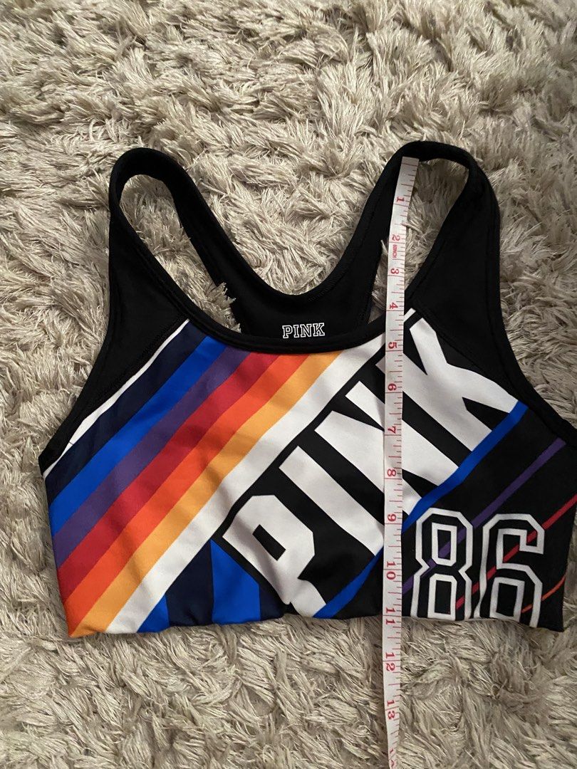 Pink Victoria's Secret Ultimate Sports Bra (Category: Activewear) located in Las Pinas. Submitted by sherylandmargaux (Listing ID 1425018955, Image 3). Description: Pink Victoria's Secret Ultimate sports bra. Features a black and colorful design with the word "PINK" and the number "86". The bra has a racerback style. The size is B75 (equivalent to a size S/D, AA75, A75). Made in Sri Lanka. The material is 88% polyester and 12% elastane..
