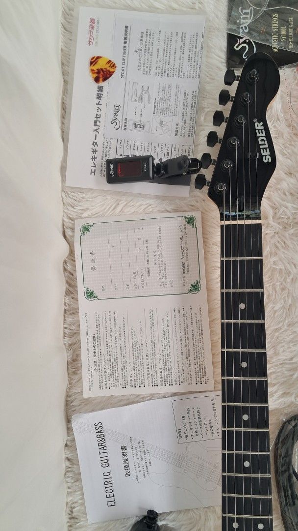 Selder Electric Guitar with Accessories (Category: Musical Instruments) located in Balagtas. Submitted by misteramarijapansurplus (Listing ID 1425049491, Image 3). Description: Selder electric guitar comes with a soft case, strap, cable, and a set of new strings. It includes a tuner and some paperwork. The guitar has a black and purple finish. The guitar has a black headstock and a rosewood fretboard. GUITAR with BAG ONLY 4500 loc Panginay Balagt
