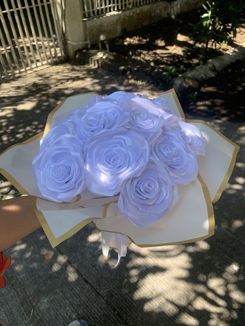 White Satin Rose Bouquet (Category: Flowers & Bouquets) located in Manila. Submitted by foreverble80256 (Listing ID 1424896430, Image 1). Description: Beautiful bouquet of white satin roses. The roses are arranged in a bouquet and wrapped in white paper with gold trim. A white ribbon is tied around the stems. Perfect for gifts or decorations. Dozen of roses All colors available Has light battery operated.