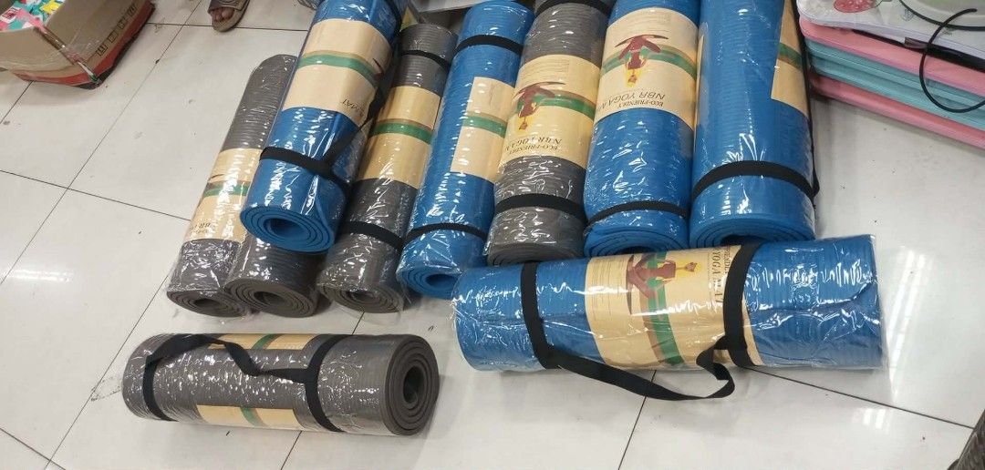 Yoga Exercise Mat (Category: Exercise Mats) located in Manila. Submitted by ncledlcrz (Listing ID 1425012429, Image 1). Description: Durable yoga exercise mats available in blue and gray. Each mat is rolled up and secured with a black strap. The mats are individually wrapped in plastic. The packaging includes a label with a logo. Perfect for home workouts or studio use..