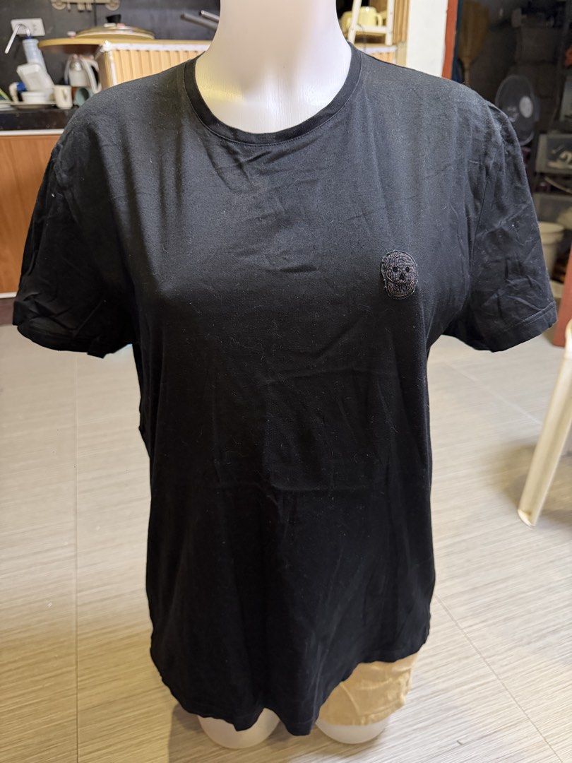 Alexander McQueen Black Skull T-shirt (Category: Luxury Apparel) located in Quezon City. Submitted by 3jsprelovedshop (Listing ID 1425155198, Image 3). Description: Black Alexander McQueen T-shirt with a skull logo. Made in Italy. Size L. The shirt has a crew neck and short sleeves. The label indicates the size as 175/100A. The shirt's measurements are L-26.5 and W-20..
