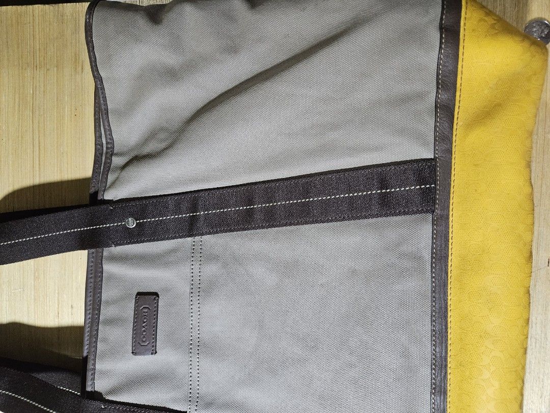 Coach Tote Bag (Category: Luxury Bags & Wallets) located in Valenzuela. Submitted by _myperfectstuff (Listing ID 1425207583, Image 1). Description: Stylish Coach tote bag featuring a grey canvas body with brown leather accents and a vibrant yellow leather base. It has sturdy handles and a spacious interior with a pocket. The bag includes a Coach logo patch. Approximate width is 20 inches. Perfect for everyday use..