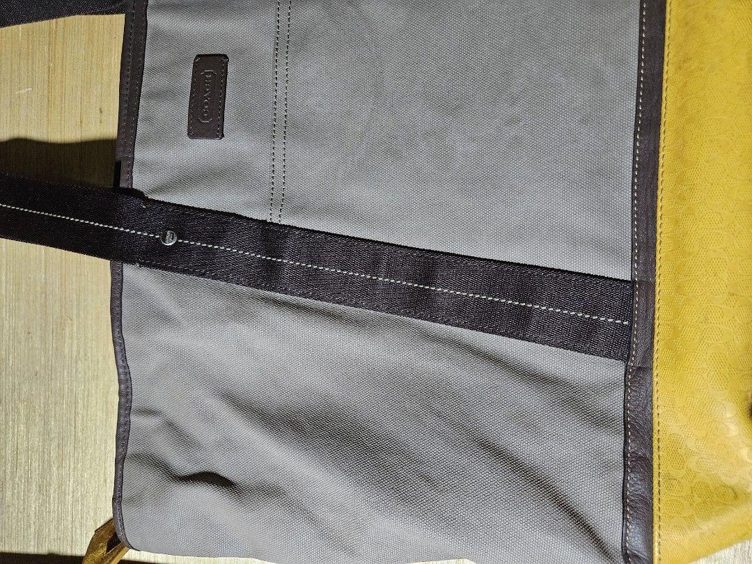 Coach Tote Bag (Category: Luxury Bags & Wallets) located in Valenzuela. Submitted by _myperfectstuff (Listing ID 1425207583, Image 2). Description: Stylish Coach tote bag featuring a grey canvas body with brown leather accents and a vibrant yellow leather base. It has sturdy handles and a spacious interior with a pocket. The bag includes a Coach logo patch. Approximate width is 20 inches. Perfect for everyday use..