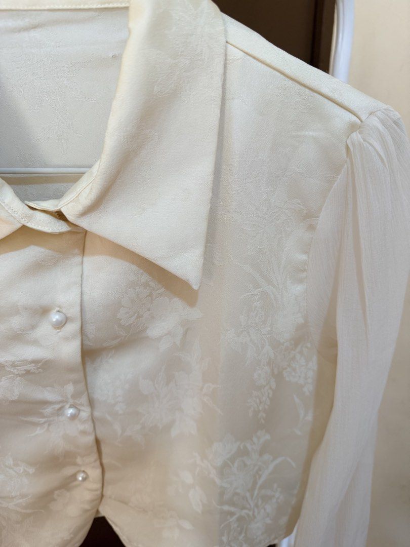 Cream-colored Cropped Blouse with Sheer Sleeves (Category: Blouses) located in Mandaluyong City. Submitted by shinyjim (Listing ID 1425077549, Image 2). Description: 🎀Dazy Paisley Patter Cream Color Collared Blouse 🎀Silk and Mesh Fabric 🎀Small on tag, 16” length 🎀Never been worn, 2nd photo closer detas 🎀Pwede pang formal, it’s giving mayora vibes 🤌.
