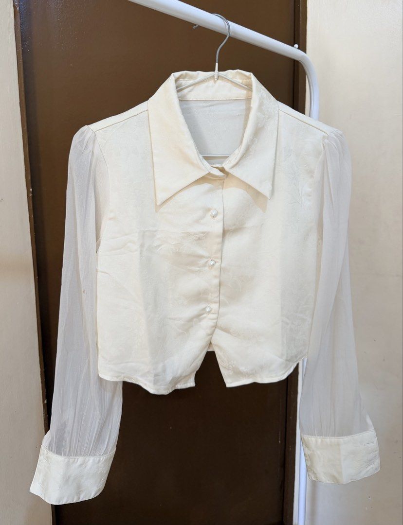Cream-colored Cropped Blouse with Sheer Sleeves (Category: Blouses) located in Mandaluyong City. Submitted by shinyjim (Listing ID 1425077549, Image 1). Description: 🎀Dazy Paisley Patter Cream Color Collared Blouse 🎀Silk and Mesh Fabric 🎀Small on tag, 16” length 🎀Never been worn, 2nd photo closer detas 🎀Pwede pang formal, it’s giving mayora vibes 🤌.