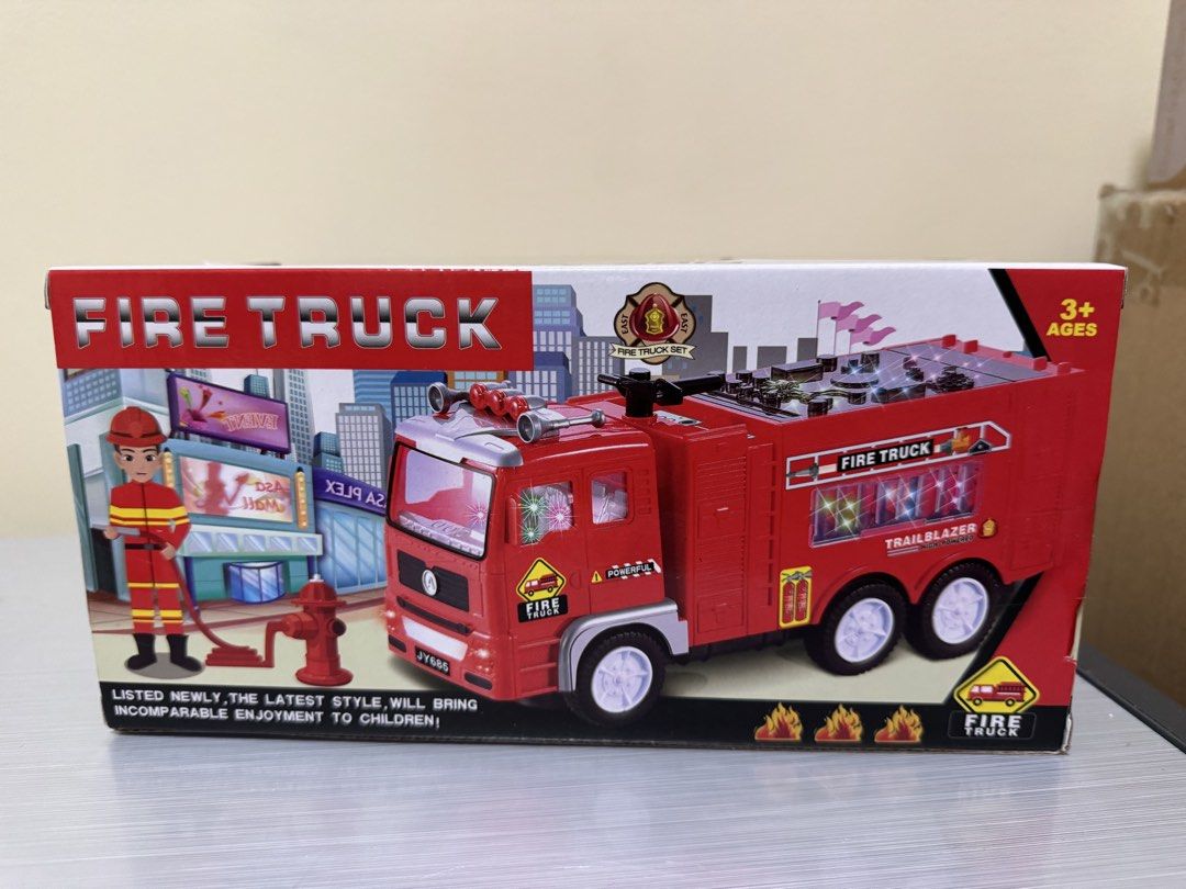 Fire Truck Toy for Ages 3+ (Category: Kids Toys) located in San Juan City. Submitted by biancaong10 (Listing ID 1425193463, Image 2). Description: Red fire truck toy suitable for children aged 3 and above. It features a detailed design with multiple wheels and a ladder. The box indicates it has lights and sounds. The toy is labeled as 'Trailblazer' and includes the words 'Fire Truck' prominently displayed on the packaging..