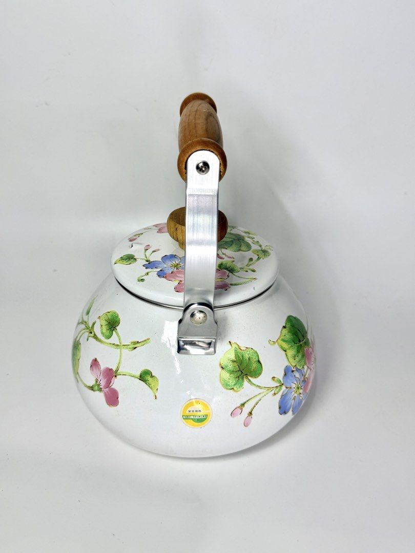 Floral Enamel Kettle (Category: Kettles & Airpots) located in Manila. Submitted by prelovedbyramiah (Listing ID 1425179514, Image 3). Description: Charming kettle features a white enamel finish adorned with delicate floral patterns. It has a wooden handle and lid knob, complemented by a stainless steel handle frame. The kettle includes a spout for easy pouring. -Unused.