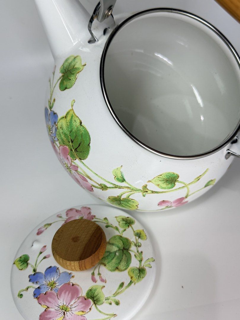 Floral Enamel Kettle (Category: Kettles & Airpots) located in Manila. Submitted by prelovedbyramiah (Listing ID 1425179514, Image 2). Description: Charming kettle features a white enamel finish adorned with delicate floral patterns. It has a wooden handle and lid knob, complemented by a stainless steel handle frame. The kettle includes a spout for easy pouring. -Unused.