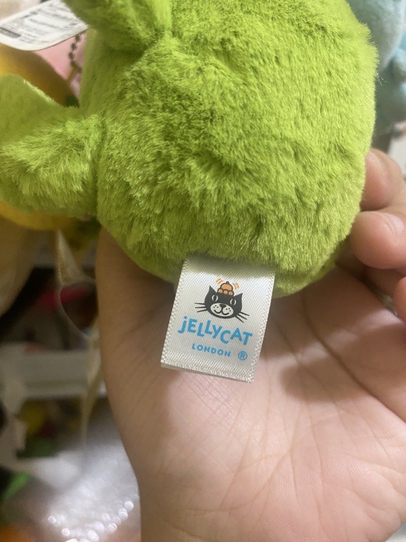 Jellycat Green Frog Keychain (Category: Plushies & Soft Toys) located in Imus. Submitted by mnmv23 (Listing ID 1425244083, Image 3). Description: Adorable Jellycat green frog plushie keychain. Features a soft, plush texture and a cute, smiling face. Includes a metal keychain ring for easy attachment to bags or keys. The tag indicates it's a Jellycat London product. A perfect gift for plushie collectors or anyone who loves cute accessories. Sold a