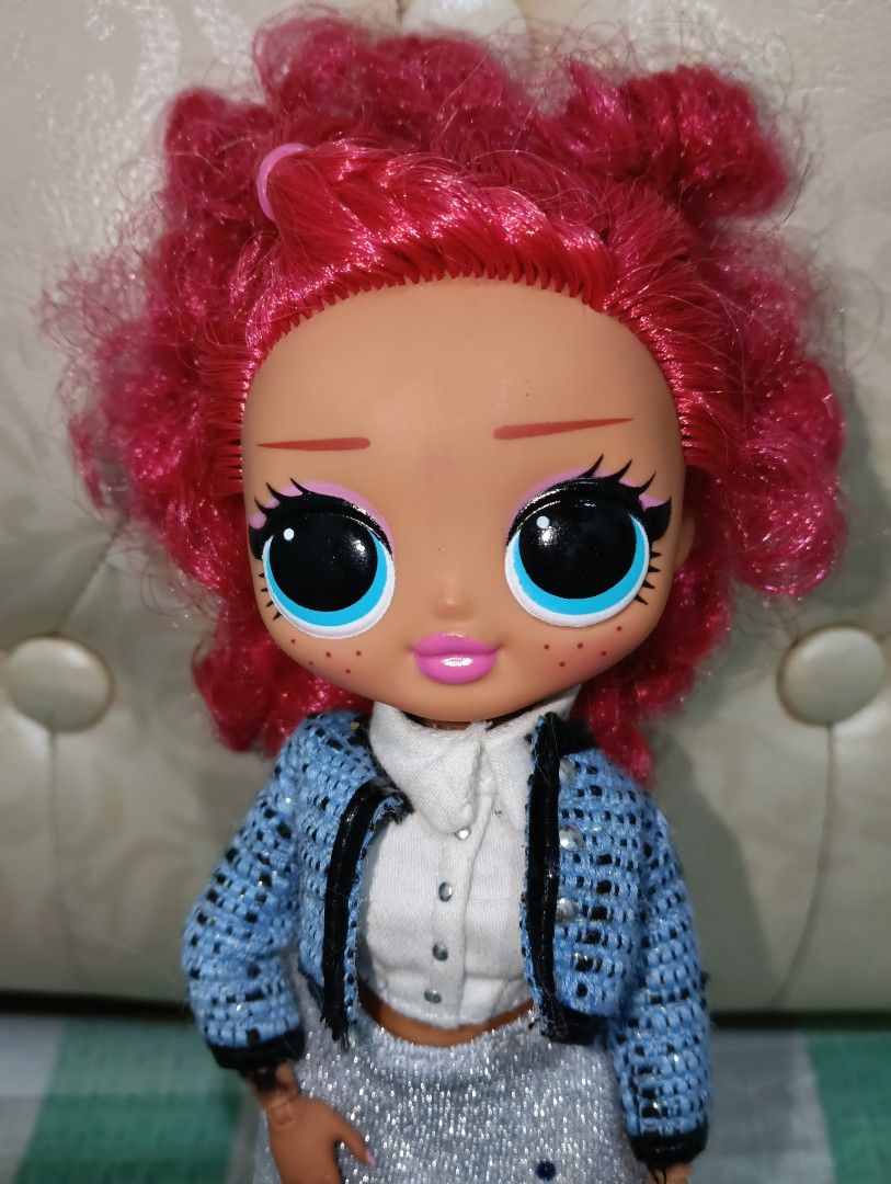 LOL Surprise OMG Doll (Category: Kids Toys) located in Angono. Submitted by lala_tan (Listing ID 1425243992, Image 2). Description: LOL Surprise OMG doll features vibrant red curly hair and striking blue eyes. She is wearing a blue jacket, a white shirt, a silver skirt, and black and white socks. The doll has a detailed face with pink lips and freckles..