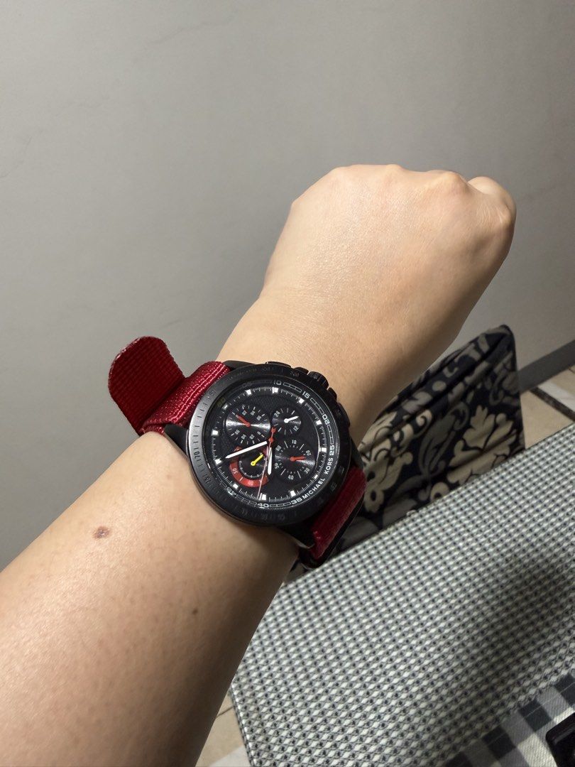 Michael Kors Black Chronograph Watch with Red Strap (Category: Luxury Watches) located in Quezon City. Submitted by TSKOauthcloset (Listing ID 1425248666, Image 1). Description: Stylish Michael Kors watch featuring a black chronograph dial and a striking red strap. The watch has a black case and a detailed dial with multiple sub-dials. The red strap complements the black case, creating a bold contrast..