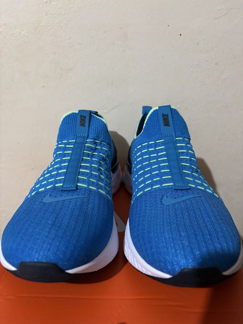Nike React Phantom Run Flyknit 2 (Category: Sneakers) located in Cavite. Submitted by kiminobukogure5 (Listing ID 1425181301, Image 2). Description: Nike React Phantom Run Flyknit 2 sneakers in blue. Features a slip-on design with a Flyknit upper. The Nike logo is visible on the tongue. The shoes are presented in an orange Nike box. RFS: Extra shoes (never used, only fitted once).