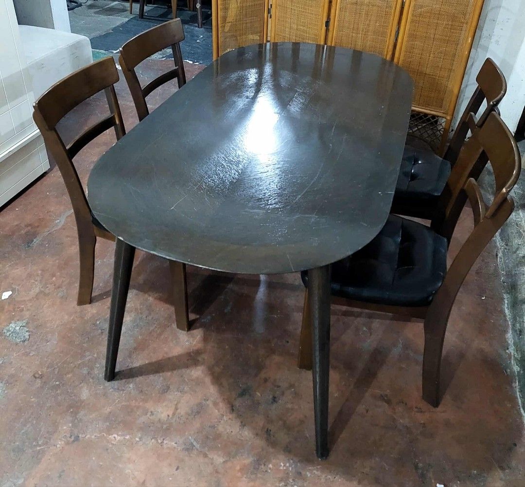 Oval Dining Table with 4 Chairs (Category: Tables & Sets) located in Manila. Submitted by wiseocean.25b393 (Listing ID 1425081206, Image 3). Description: Elegant oval dining table with four matching chairs. The table has a dark finish and sleek legs. The chairs feature wooden frames with black cushioned seats. Table dimensions: H-28", L-59", W-32". Chair dimensions: H-17/33", L-16", W-16". Perfect for a small dining area or kitchen..
