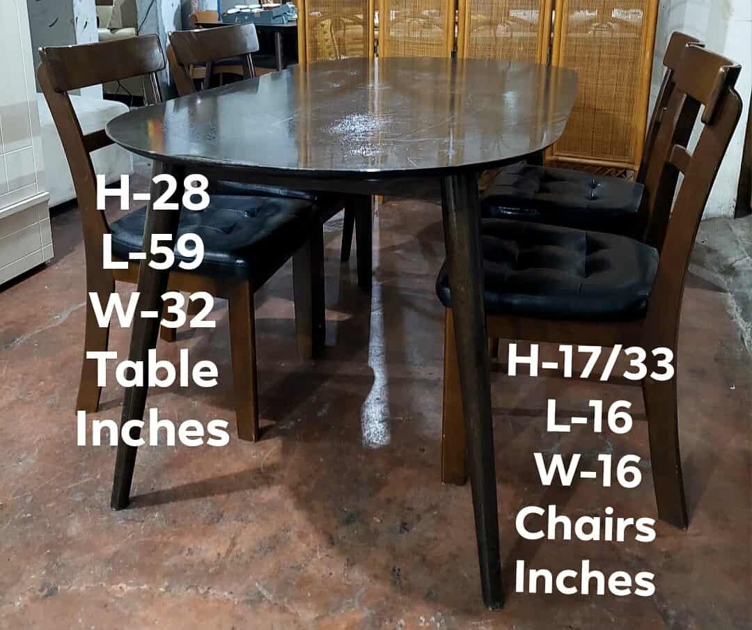Oval Dining Table with 4 Chairs (Category: Tables & Sets) located in Manila. Submitted by wiseocean.25b393 (Listing ID 1425081206, Image 1). Description: Elegant oval dining table with four matching chairs. The table has a dark finish and sleek legs. The chairs feature wooden frames with black cushioned seats. Table dimensions: H-28", L-59", W-32". Chair dimensions: H-17/33", L-16", W-16". Perfect for a small dining area or kitchen..