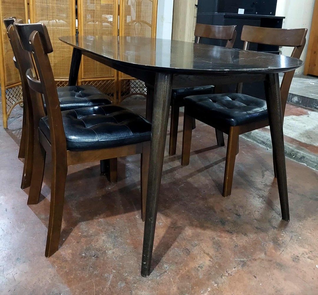 Oval Dining Table with 4 Chairs (Category: Tables & Sets) located in Manila. Submitted by wiseocean.25b393 (Listing ID 1425081206, Image 2). Description: Elegant oval dining table with four matching chairs. The table has a dark finish and sleek legs. The chairs feature wooden frames with black cushioned seats. Table dimensions: H-28", L-59", W-32". Chair dimensions: H-17/33", L-16", W-16". Perfect for a small dining area or kitchen..
