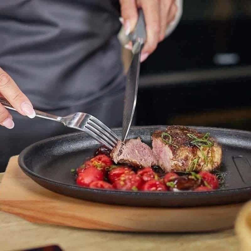 Oval Sizzling Plate with Wooden Base (Category: Cookware & Accessories) located in Manila. Submitted by yzcartph (Listing ID 1425075243, Image 1). Description: Sizzling plate is perfect for serving various dishes like steak, fried eggs, and fried rice. It comes with a wooden base for easy handling and serving. The plate is oval-shaped with a black finish and features grill lines. It's ideal for both home cooking and restaurant use. The plate is s