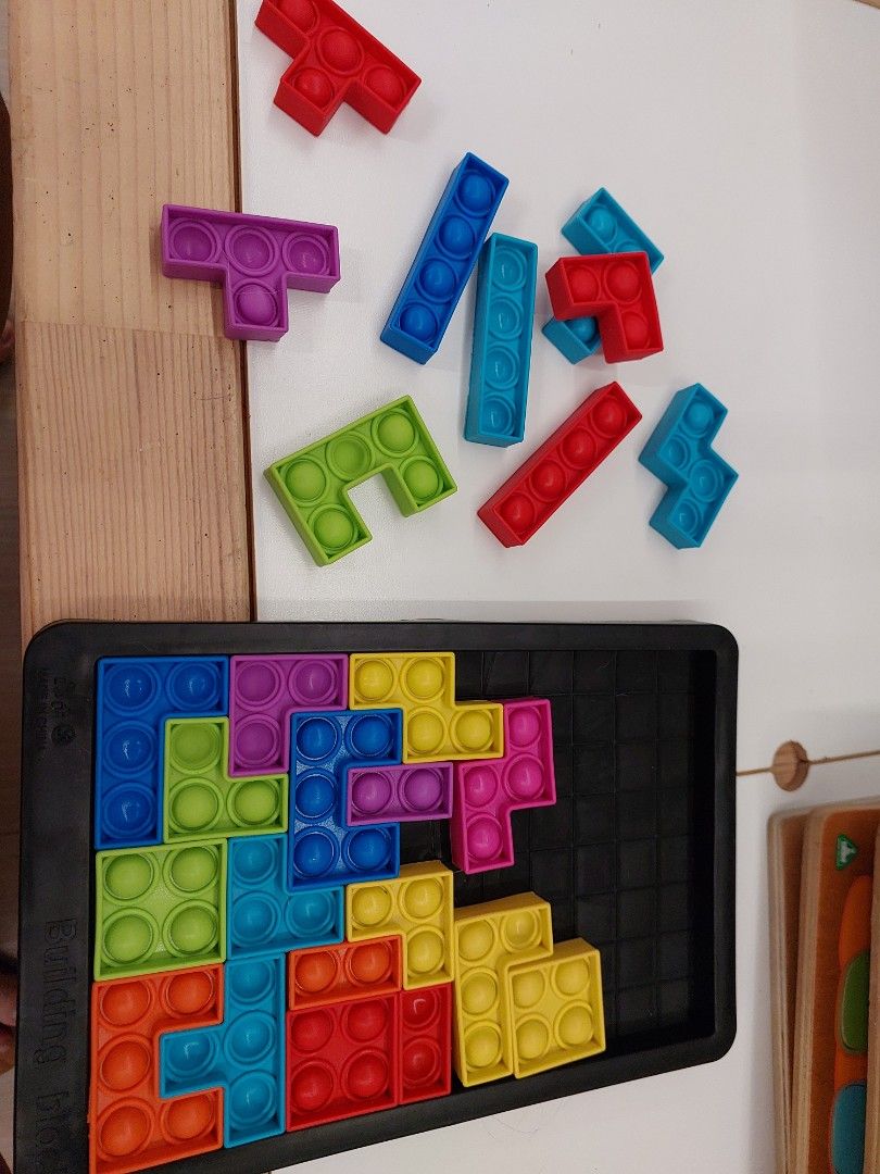 Pop It Tetris Puzzle Game (Category: Board Games & Puzzles) located in Cavite. Submitted by babyandkidsthriftshop (Listing ID 1425238445, Image 2). Description: Colorful Pop It Tetris puzzle game. It includes a black tray and multiple Tetris-shaped pieces in various colors. The pieces can be arranged to fit into the tray. It is a fun and engaging toy for kids and adults alike..