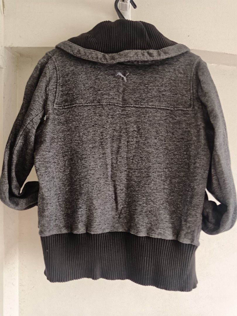 AS IS: Puma Vintage Gray Jacket with Hood (Category: Coats, Jackets and Outerwear) located in San Juan City. Submitted by frugala (Listing ID 1425090311, Image 3). Description: *Puma Button Zip-Up Y2K Charcoal 2008s* Gray Puma jacket with a hood. Features a zipper closure and button details. Ribbed/ woven pattern. The jacket has a ribbed hem and cuffs w/ visible signs of wear. The Puma logo is visible on the chest. With small tear (not a hole) on