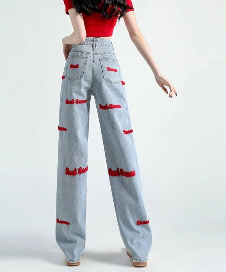 Red Embroidered Wide Leg Denim Jeans (Category: Jeans) located in Cavite. Submitted by cvshops (Listing ID 1425206599, Image 2). Description: 24-26 with belt slot Sobrang ganda ng fitting 39-40 length 399-450+ price online Light wash denim jeans with red embroidered text. Features a wide leg design. The jeans have a high waist and a classic style. The red embroidery is visible on the front and back of the jeans. These jeans are a stylish and comf
