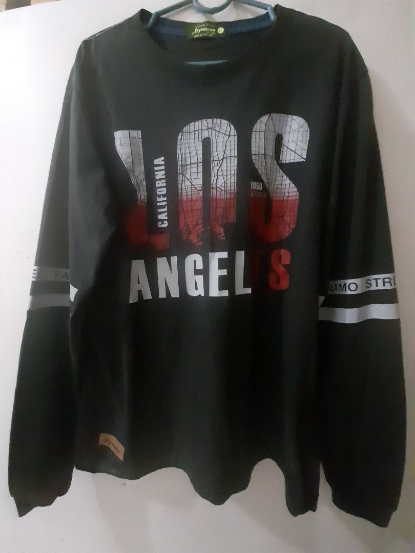 Black Los Angeles Sweatshirt (Category: Coats, Jackets and Outerwear) located in Caloocan City. Submitted by lourdespad77562 (Listing ID 1425346258, Image 1). Description: Black long-sleeved Roundneck Shirt with "LOS ANGELES CALIFORNIA" printed on the front. Features a map design within the letters. The sleeves have a white stripe with text. The sweatshirt has a round neck and a tag on the collar..