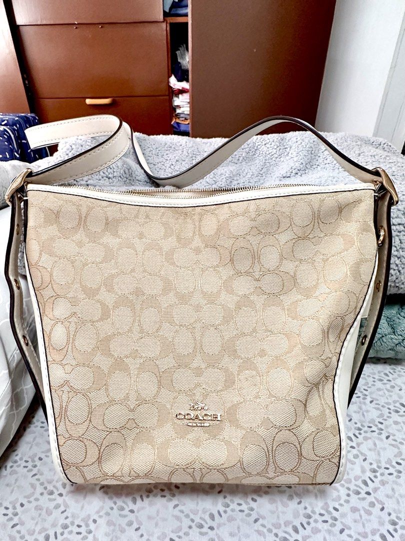 Coach Jacquard Dufflette Bag (Category: Luxury Bags & Wallets) located in Malolos. Submitted by layntev (Listing ID 1425309491, Image 1). Description: Coach - Beige & Cream “Jacquard Dufflette” Bag Stay polished and prepared on-the-go with the Coach “Jacquard Dufflette” Bag. The custom-woven jacquard and smooth leather trim exude luxury, while the gold-tone hardware adds a touch of elegance. The versatile beige and cream color scheme makes this s