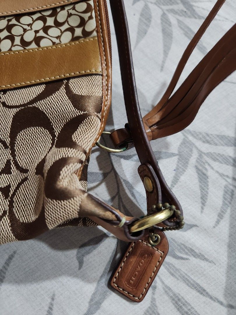 Coach Signature Hobo Bag (Category: Luxury Bags & Wallets) located in Manila. Submitted by juneuy (Listing ID 1425347664, Image 3). Description: Authentic Coach signature hobo bag with a brown leather strap and accents. Features a main compartment with a zipper closure. The bag has a brown and tan signature pattern with a leather base. Includes a Coach hang tag and a tassel detail..