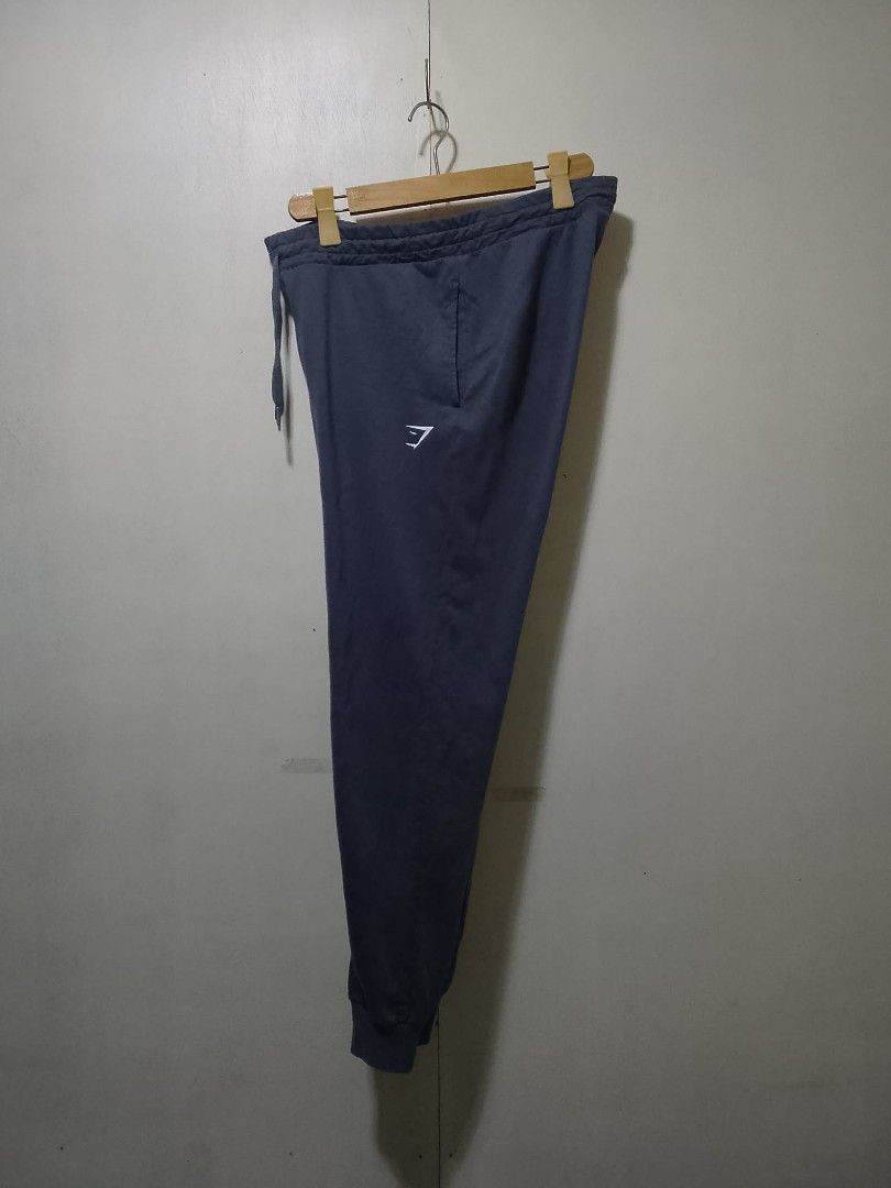 Gymshark Jogger Pants - Gray - Medium (Category: Joggers) located in Cabuyao City. Submitted by max_0198 (Listing ID 1425362002, Image 2). Description: Gymshark jogger pants in gray. Features a drawstring waist and the Gymshark logo on the left leg. The pants have cuffed ankles and a relaxed fit. Made in Mauritius. Size M..
