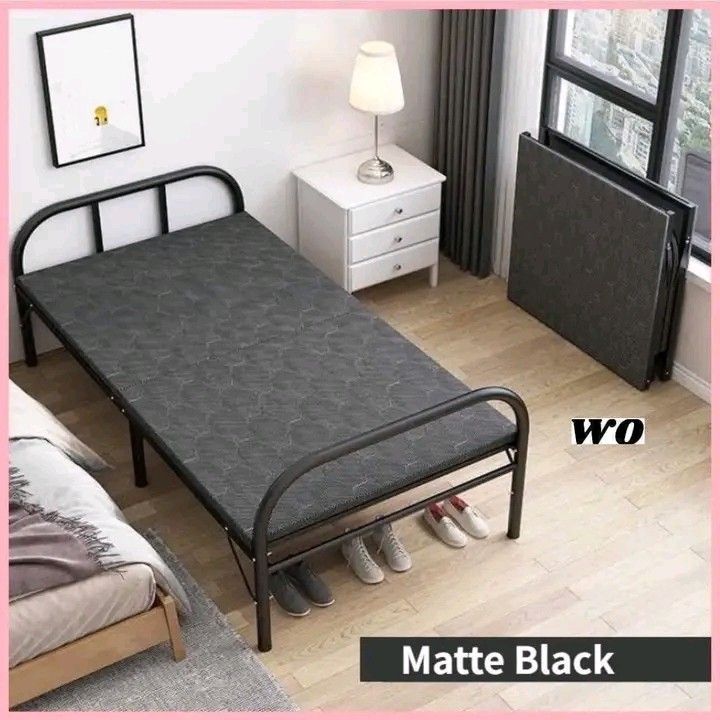Matte Black Folding Bed (Category: Bed Frames & Mattresses) located in Makati City. Submitted by oideme (Listing ID 1425257648, Image 2). Description: Folding bed features a matte black frame and a gray patterned mattress. The bed is suitable for various spaces and can be used as a guest bed or for temporary sleeping arrangements. It is a practical and space-saving solution for your home..