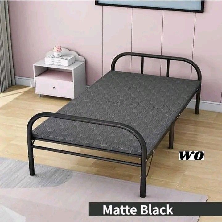 Matte Black Folding Bed (Category: Bed Frames & Mattresses) located in Makati City. Submitted by oideme (Listing ID 1425257648, Image 1). Description: Folding bed features a matte black frame and a gray patterned mattress. The bed is suitable for various spaces and can be used as a guest bed or for temporary sleeping arrangements. It is a practical and space-saving solution for your home..