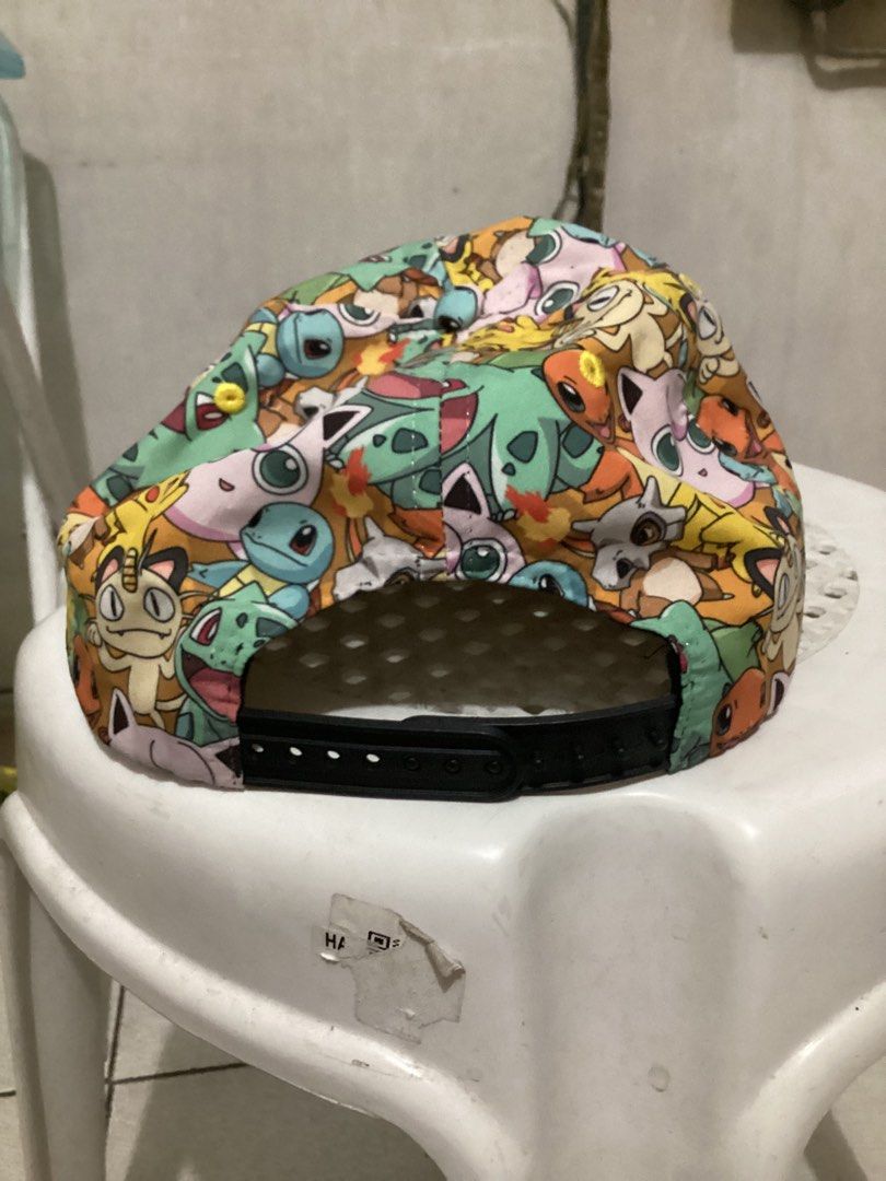 Pokemon All-Over Print Cap (Category: Caps & Hats) located in Caloocan City. Submitted by lostrtrp (Listing ID 1425378562, Image 3). Description: Cap features an all-over print of various Pokemon characters. It has a black brim and a snapback closure for adjustable sizing. The interior includes a white mesh lining for breathability. The tag indicates it is made in China and intended for ages 14 and older..
