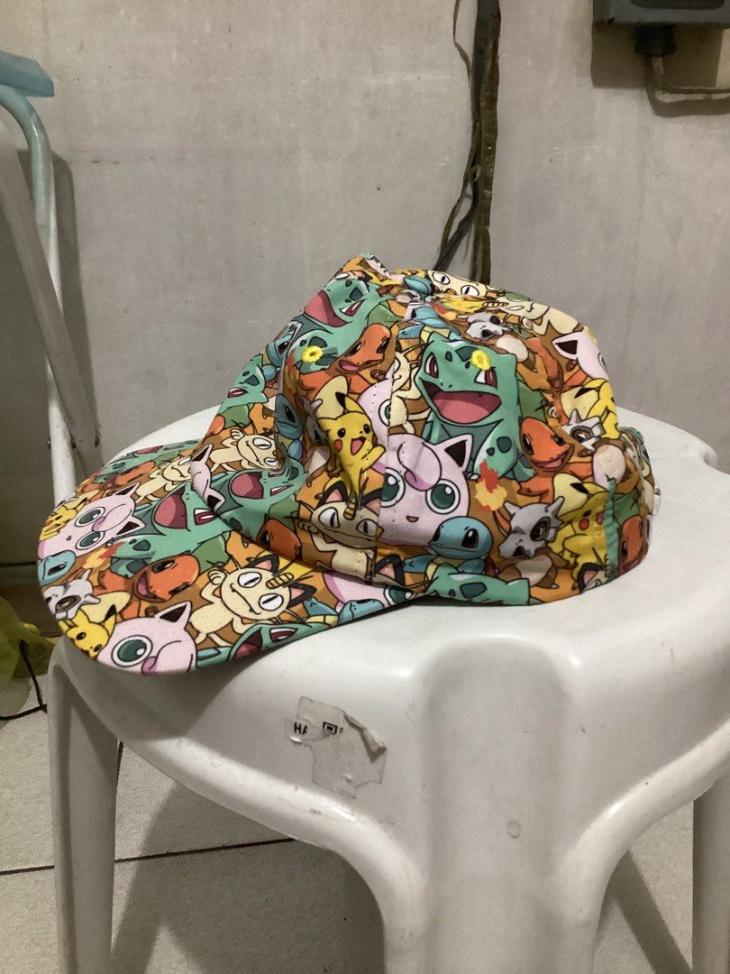 Pokemon All-Over Print Cap (Category: Caps & Hats) located in Caloocan City. Submitted by lostrtrp (Listing ID 1425378562, Image 2). Description: Cap features an all-over print of various Pokemon characters. It has a black brim and a snapback closure for adjustable sizing. The interior includes a white mesh lining for breathability. The tag indicates it is made in China and intended for ages 14 and older..