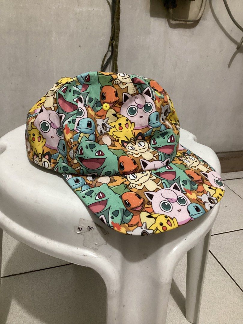 Pokemon All-Over Print Cap (Category: Caps & Hats) located in Caloocan City. Submitted by lostrtrp (Listing ID 1425378562, Image 1). Description: Cap features an all-over print of various Pokemon characters. It has a black brim and a snapback closure for adjustable sizing. The interior includes a white mesh lining for breathability. The tag indicates it is made in China and intended for ages 14 and older..