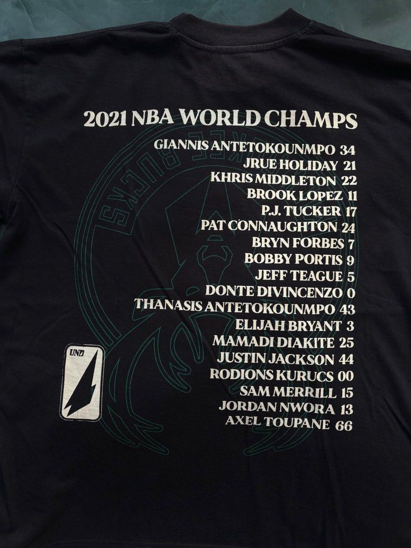 Undrafted NBA World Champs 2021 Bucks Tee (Category: Tshirts & Polo Shirts ) located in Paranaque City. Submitted by fusionquazar (Listing ID 1424611530, Image 3). Description: - Official Undrafted NBA World Champs 2021 Milwaukee Bucks tee. - Features a graphic of the team and the words "FEAR THE DEER". - Player names listed on the back. - Size: 2XL.