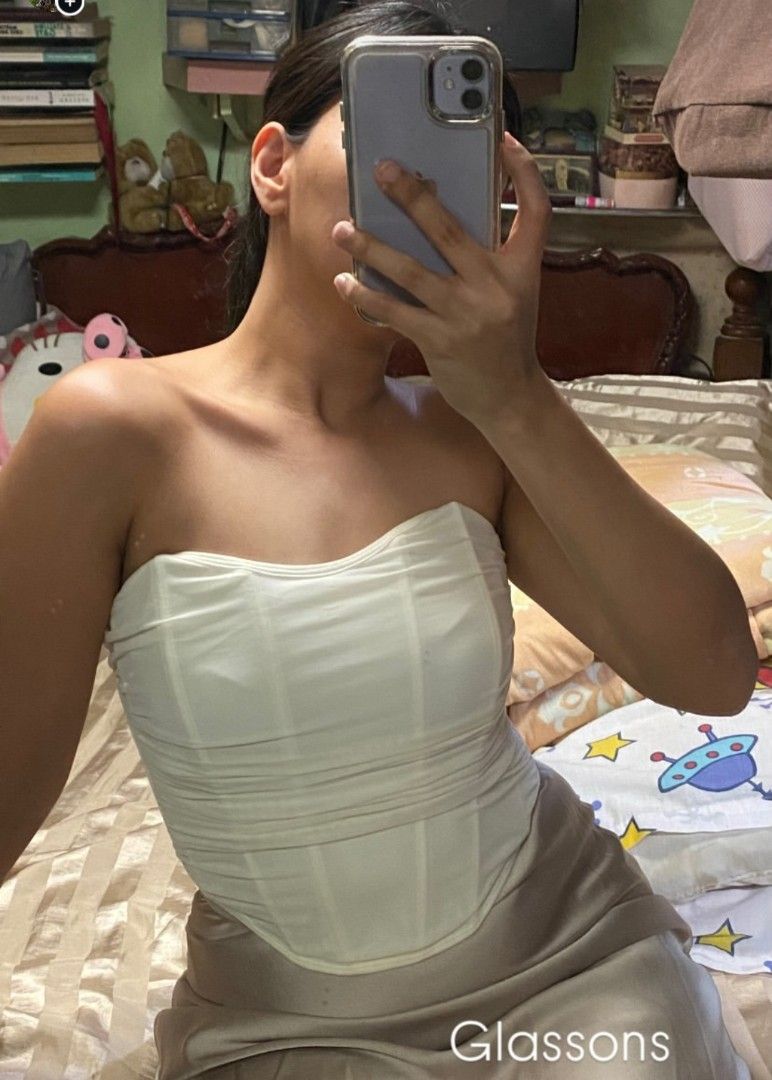 White Corset Top (Category: Sleeveless) located in Quezon City. Submitted by declutterwithmeeeeeeeeeee (Listing ID 1425317579, Image 3). Description: White corset top. Features a strapless design with a structured bodice. The top has a ruched or gathered fabric detail. The top is suitable for various occasions. brand: Glassons.