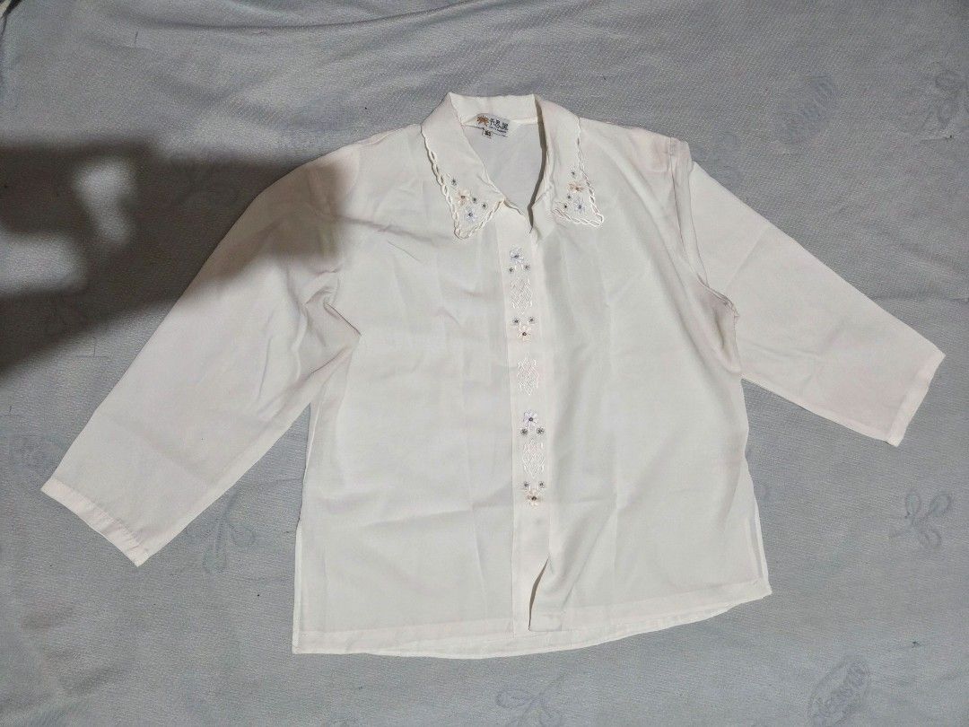 White Embroidered Blouse (Category: Blouses) located in Manila. Submitted by declutterwtly (Listing ID 1425416905, Image 1). Description: Please DM me for your offers, TYSM! 💌 -Elegant white blouse with delicate embroidery details. -Features long sleeves and a button-down front. -The collar and front panel are adorned with floral embroidery. -A classic piece suitable for various occasions..