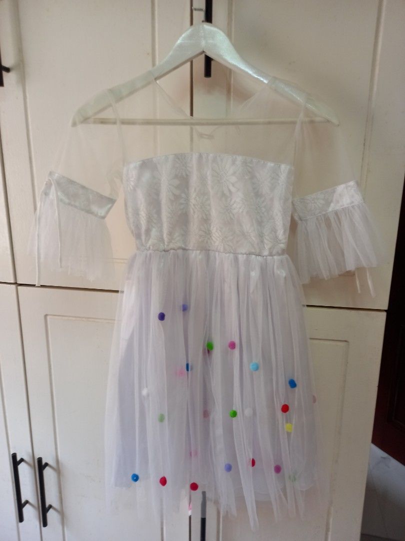 White Tulle Dress with Bow (Category: Dresses) located in Manila. Submitted by zenphoenix-7ad615 (Listing ID 1425296351, Image 2). Description: Beautiful white tulle dress features a sparkly bodice and delicate sleeves. The dress is adorned with colorful polka dots and a charming bow. Perfect for special occasions or a fun photoshoot. The dress is lightweight and airy, making it comfortable to wear. It is a lovely choice for any little girl..