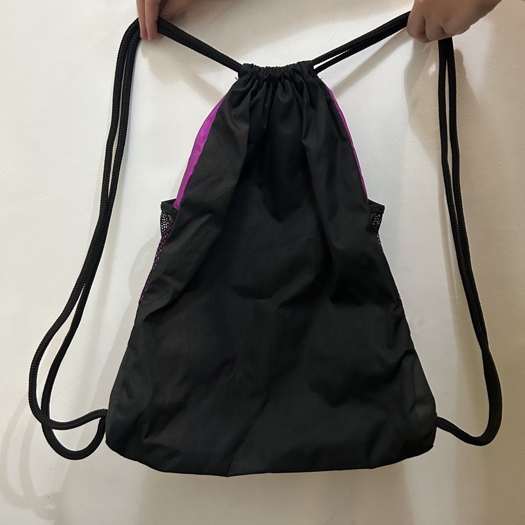 Adidas Drawstring Bag with Front Pocket (Category: Backpacks) located in Baguio. Submitted by rmlst.coll (Listing ID 1425536636, Image 2). Description: Adidas drawstring bag in purple, teal, and black. Features a front zippered pocket and a mesh side pocket. The bag has the Adidas logo on the bottom. The drawstring closure is black. The bag is designed with three teal stripes down the front..