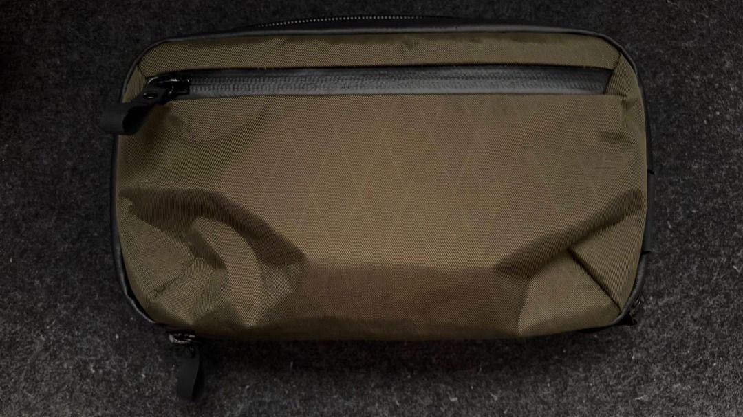 Alpaka Elements Tech Case Mini Olive Green Pouch with Zipper (Category: Purses & Pouches) located in Las Pinas. Submitted by mindlessghost (Listing ID 1425488317, Image 1). Description: Pouch features a sleek olive green exterior with a black zipper. It has a rectangular shape with a small pocket on the front. It's a compact size, perfect for carrying essentials. The pouch has a minimalist design..
