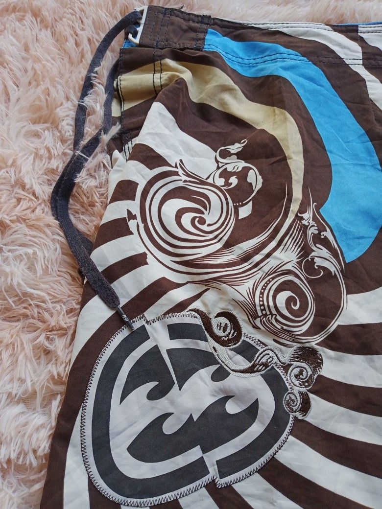 Billabong Board Shorts (Category: Swim Trunks & Board Shorts) located in Boston. Submitted by johnpaulvi30029 (Listing ID 1425476339, Image 2). Description: Stylish Billabong board shorts featuring a unique swirl design in brown, blue, and white. These shorts have a drawstring closure and a back pocket. The Billabong logo is embroidered on the front. Perfect for the beach or casual wear..