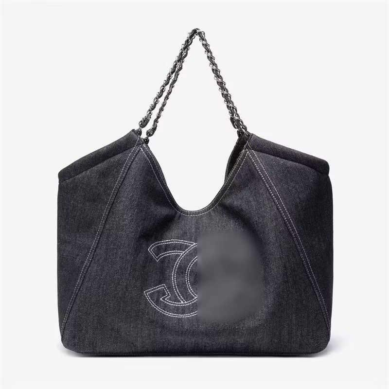 Denim Tote Bag (Category: Luxury Bags & Wallets) located in Makati City. Submitted by mccuachon (Listing ID 1425574272, Image 1). Description: Stylish Large Black Denim Tote Bag crafted from denim fabric. Features a chain strap and the iconic Ch@nel logo prominently displayed on the front. The bag has a spacious interior, perfect for everyday use. The stitching details add a touch of elegance to the design. A versatile accessory that complements 