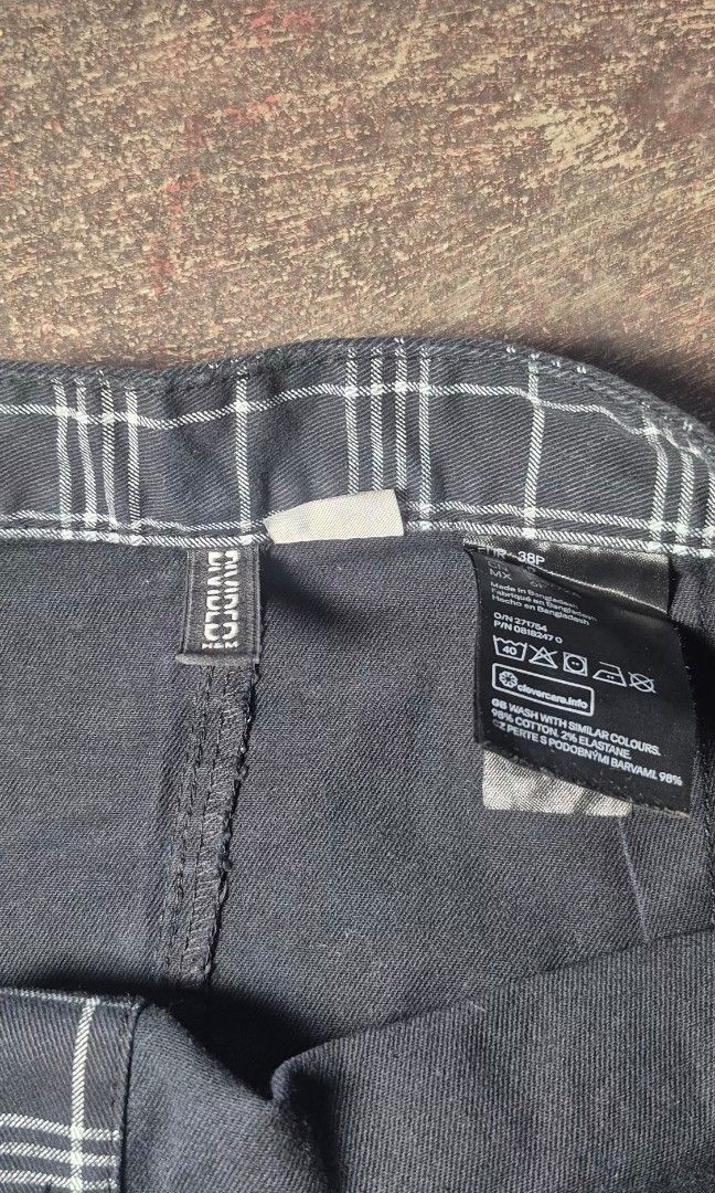 Divided Plaid Button-Up Skirt (Category: Skirts) located in Manila. Submitted by declutter_s (Listing ID 1425587226, Image 3). Description: Skirt features a classic plaid pattern with a button-up design. It has a mini length and a fitted silhouette. It has a black and white color scheme. The skirt has a button closure..