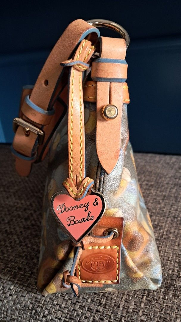 Dooney & Bourke Bee Print Handbag (Category: Clutches) located in Santa Rosa. Submitted by majanice (Listing ID 1425518851, Image 3). Description: Dooney &Bourke Pochette bag Bee print leather strap and trims very good hardware and leather canvass bag great addition to Dooney fan and collector! condition: very good leather and hardware clean inside flaw is mainly on the bag the canvass deteriorated in its color .