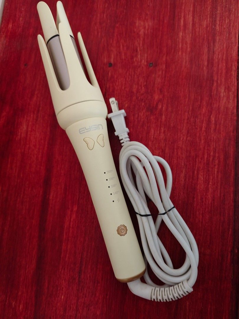 EYSIN Automatic Hair Curler (Category: Hair) located in Tarlac. Submitted by clarion.picks (Listing ID 1425484198, Image 1). Description: EYSIN automatic hair curler features a green -colored body. It has a unique design with a curling mechanism and a long white power cord. The curler has indicator lights and a butterfly wings-like emblem..