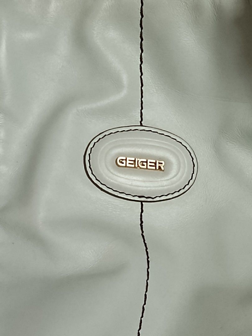 Geiger Leather Handbag (Category: Luxury Bags & Wallets) located in Batangas. Submitted by espresso.macchiato (Listing ID 1425541219, Image 3). Description: Stylish Geiger handbag in a light blue color. Features multiple zippered compartments and gold-toned hardware. The interior is lined with a branded fabric. Includes a small interior pocket. The bag has a top handle design with adjustable straps. The bag has some visible wear on the interior l