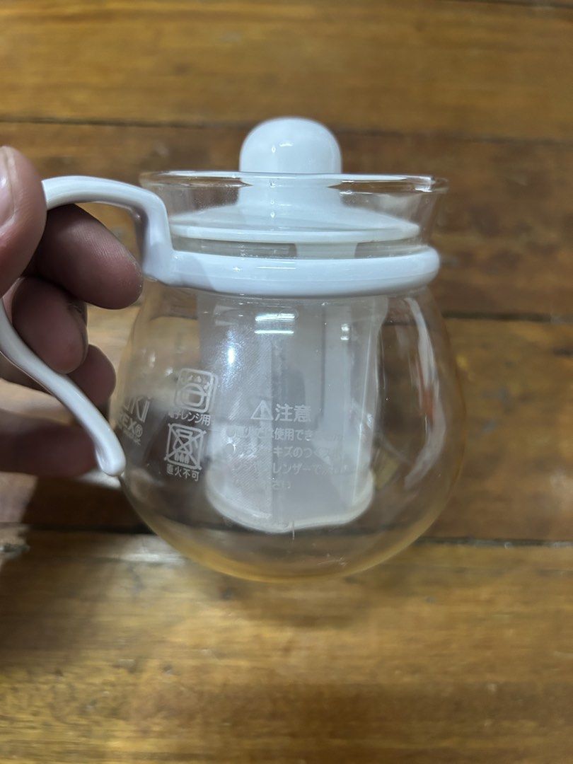 Glass Teapot with Infuser (Category: Coffee & Tea Tableware) located in Manila. Submitted by potchi.thrifts (Listing ID 1425548183, Image 1). Description: Glass teapot features a white handle, lid, and infuser. It has a clear glass body, allowing you to see the contents. The lid has a small knob for easy handling. It is a compact size, suitable for individual servings..
