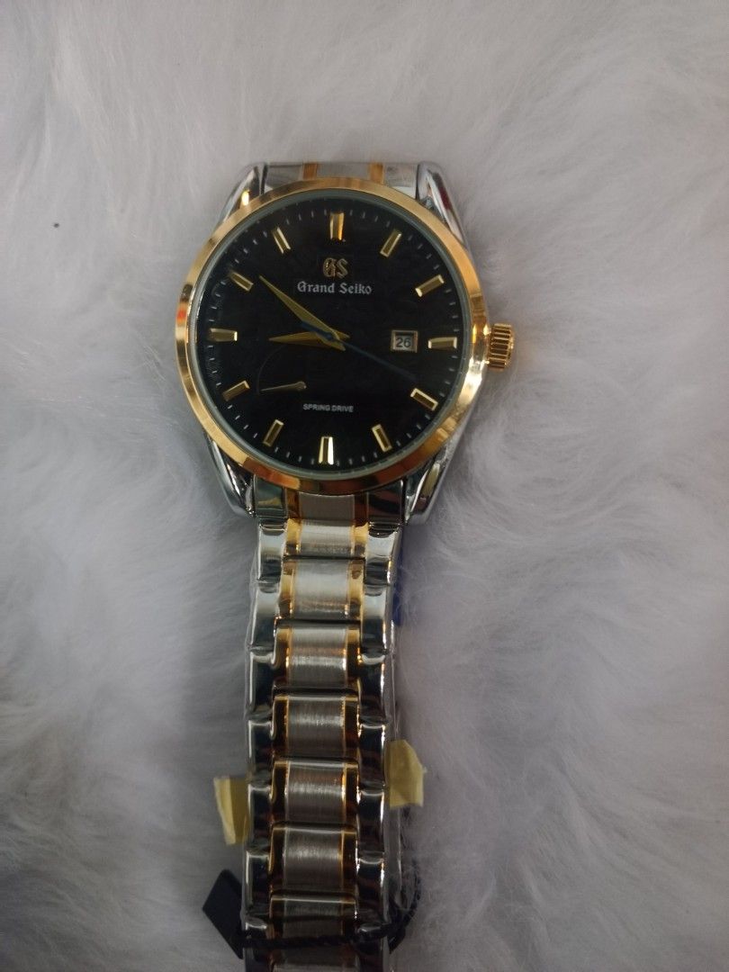 Grand Seiko Spring Drive Watch (Category: Luxury Watches) located in Manila. Submitted by crustynico23 (Listing ID 1425492062, Image 2). Description: Elegant Grand Seiko watch with a black dial and gold accents. Features a two-tone silver and gold bracelet. The watch has a visible automatic movement on the back. Includes a Seiko 5 tag. Made in Japan..