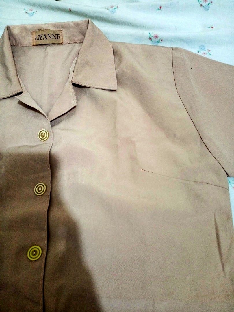 Lizanne Short Sleeve Blouse (Category: Blouses) located in Bulacan. Submitted by sssssage (Listing ID 1425604035, Image 1). Description: *Size: Small Short-sleeved blouse from Lizanne. It features a collared neckline and a button-down front. The blouse has a single pocket on the left side. The color is a light brown or beige..