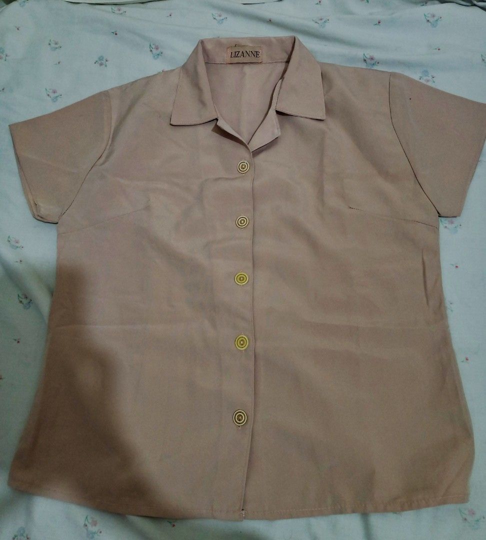 Lizanne Short Sleeve Blouse (Category: Blouses) located in Bulacan. Submitted by sssssage (Listing ID 1425604035, Image 2). Description: *Size: Small Short-sleeved blouse from Lizanne. It features a collared neckline and a button-down front. The blouse has a single pocket on the left side. The color is a light brown or beige..