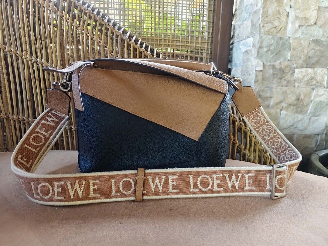 Loewe Puzzle Bag with Shoulder Strap (Category: Luxury Bags & Wallets) located in Camalig. Submitted by nasayaocat86662 (Listing ID 1417826910, Image 2). Description: - Loewe Puzzle Bag - Color block design: Black and tan leather - Detachable tan shoulder strap - Loewe logo on strap - Flap closure.